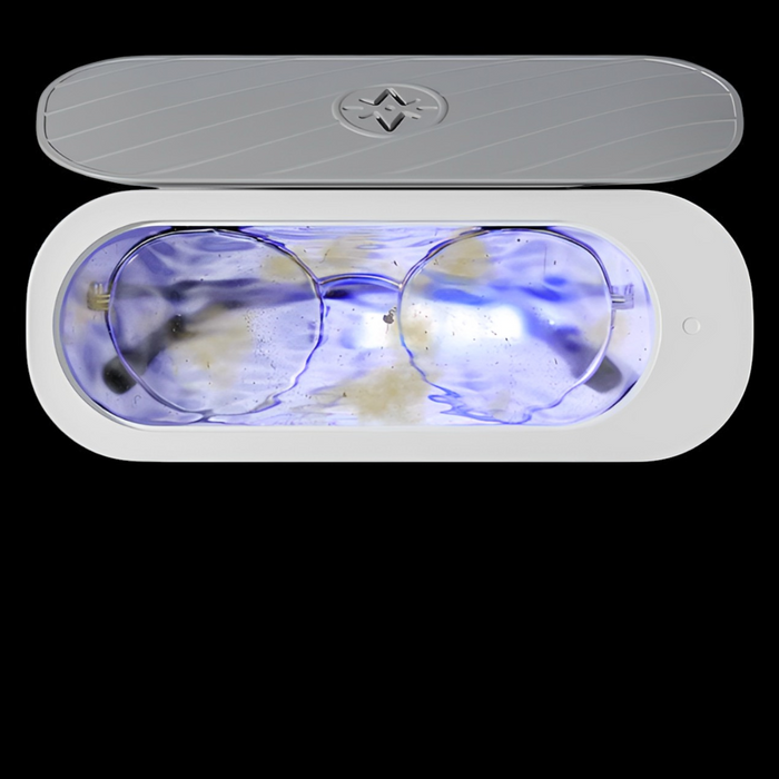 Glasses submerged in the Rushify Ultrasonic Cleaner basin, water turning cloudy as it lifts out dirt and grime